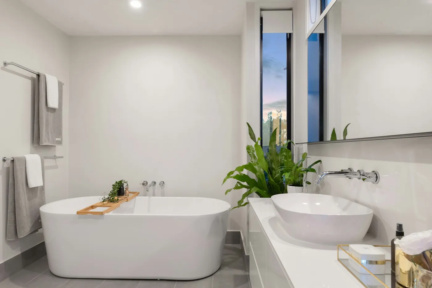 The finished bath: a bright vanity with a vessel sink and wide mirror