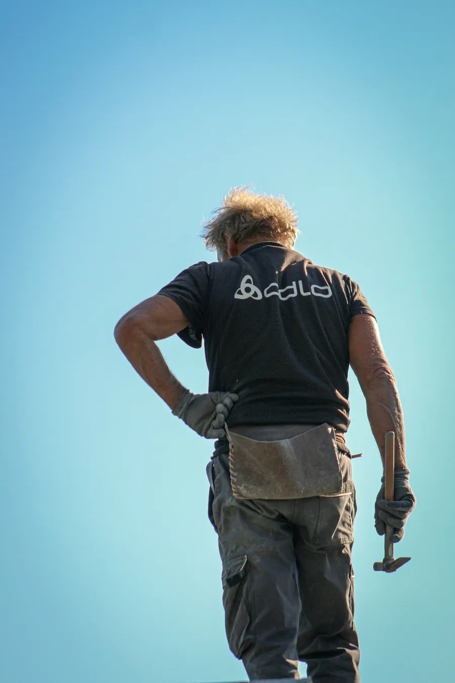 Mateo Ibarra at work on a stone course, back to the camera