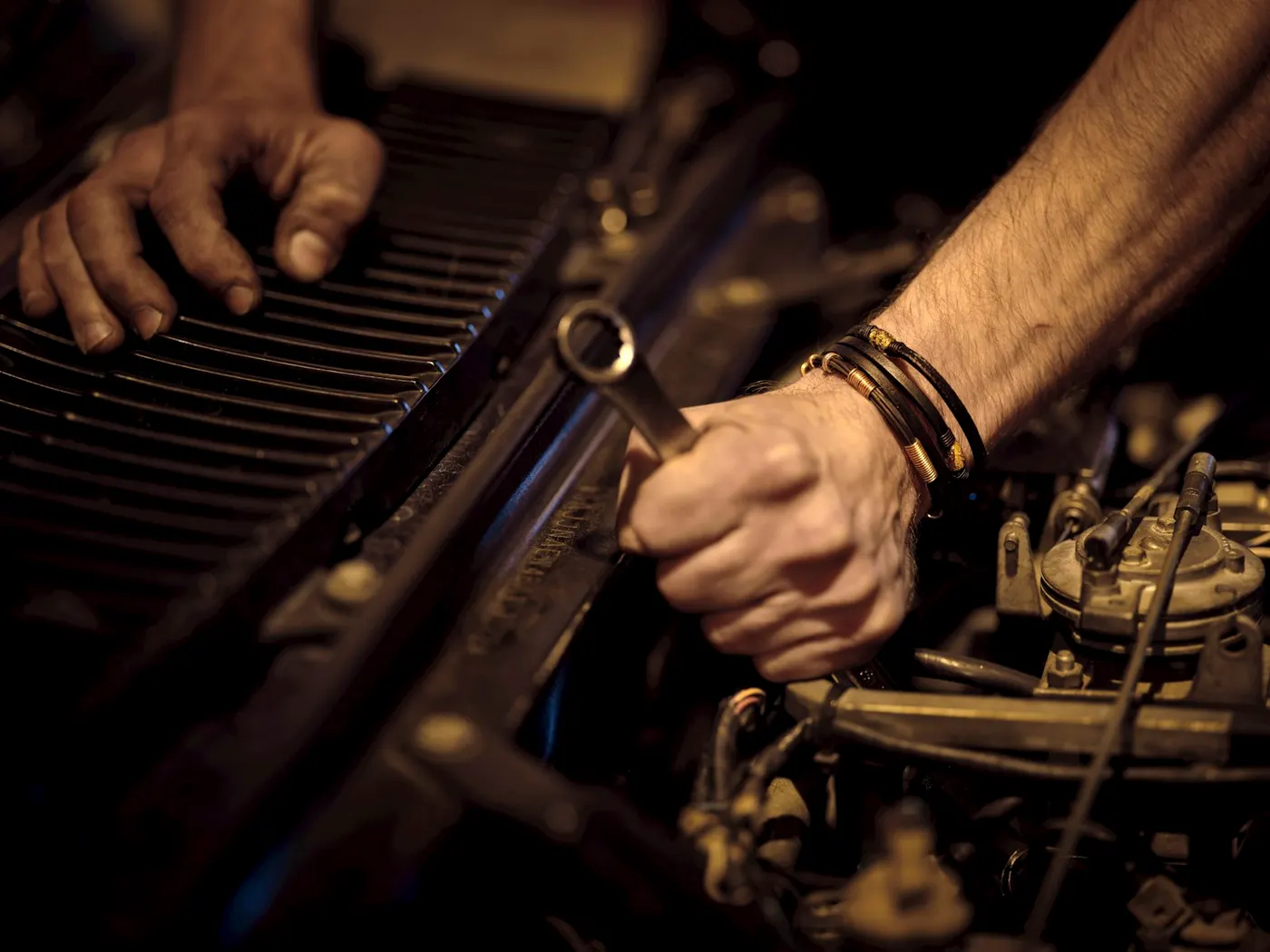 A mechanic's hands at work on an engine in the shop